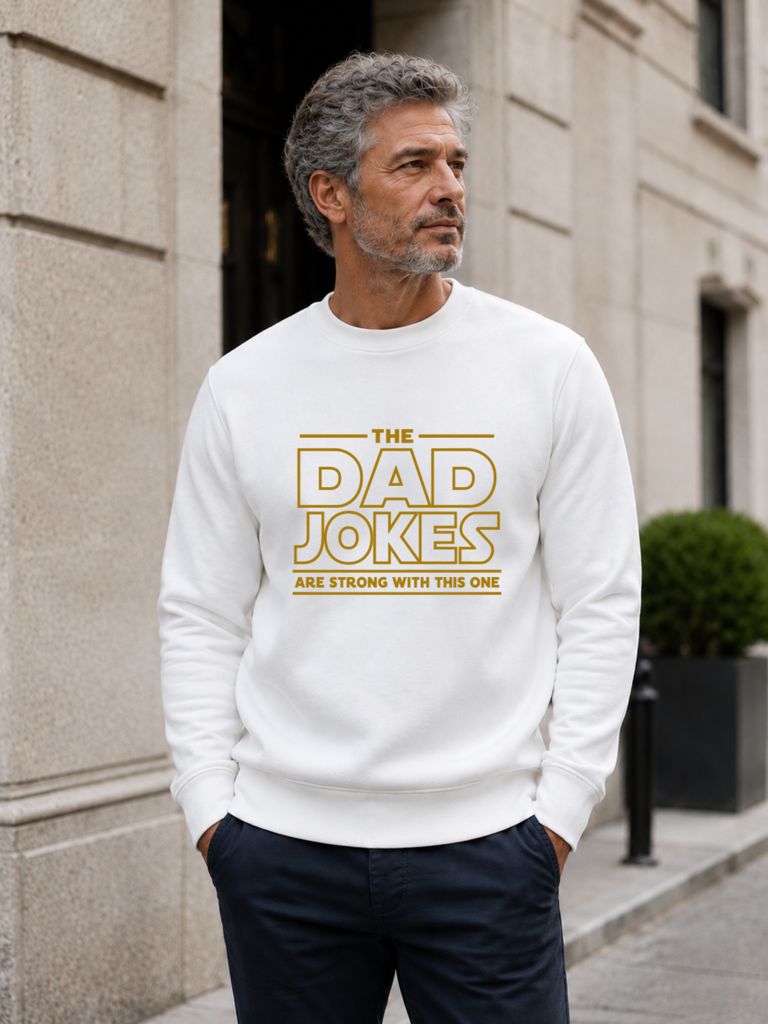 sweatshirt featuring a bold yellow “The Dad Jokes Are Strong With This One” design, modeled as a funny Father’s Day gift for dads who love humor.