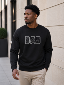 Minimalist black dad sweatshirt with white outline family artwork inside DAD lettering worn by male model outdoors.