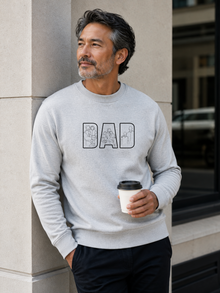 Minimalist grey dad sweatshirt with white outline family artwork inside DAD lettering worn by male model outdoors.