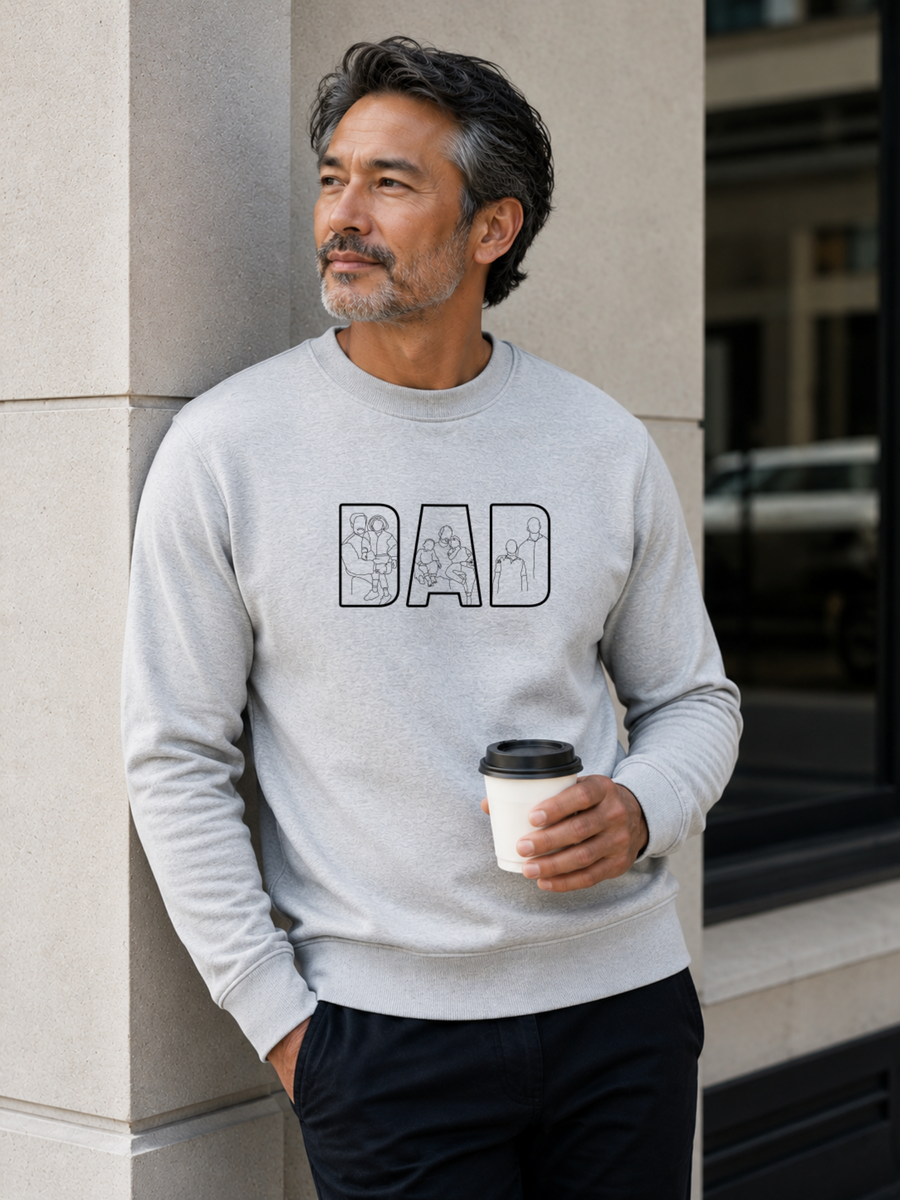 Minimalist grey dad sweatshirt with white outline family artwork inside DAD lettering worn by male model outdoors.