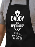 personalized Daddy The Master Chef BBQ apron with custom kids names worn by dad grilling outdoors.