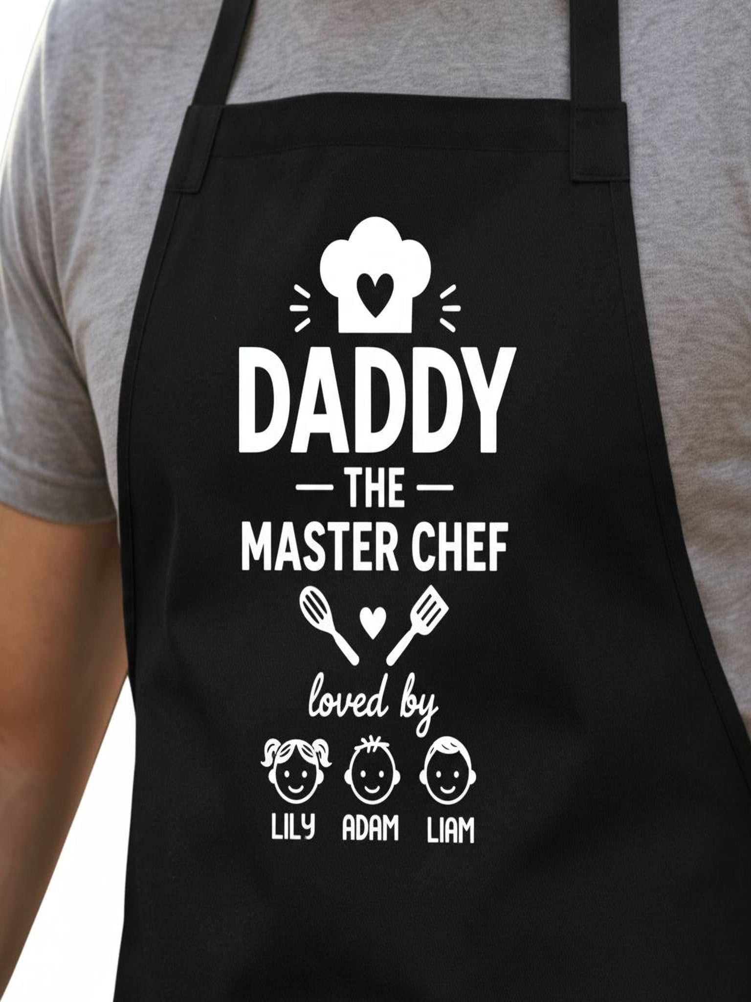 personalized Daddy The Master Chef BBQ apron with custom kids names worn by dad grilling outdoors.