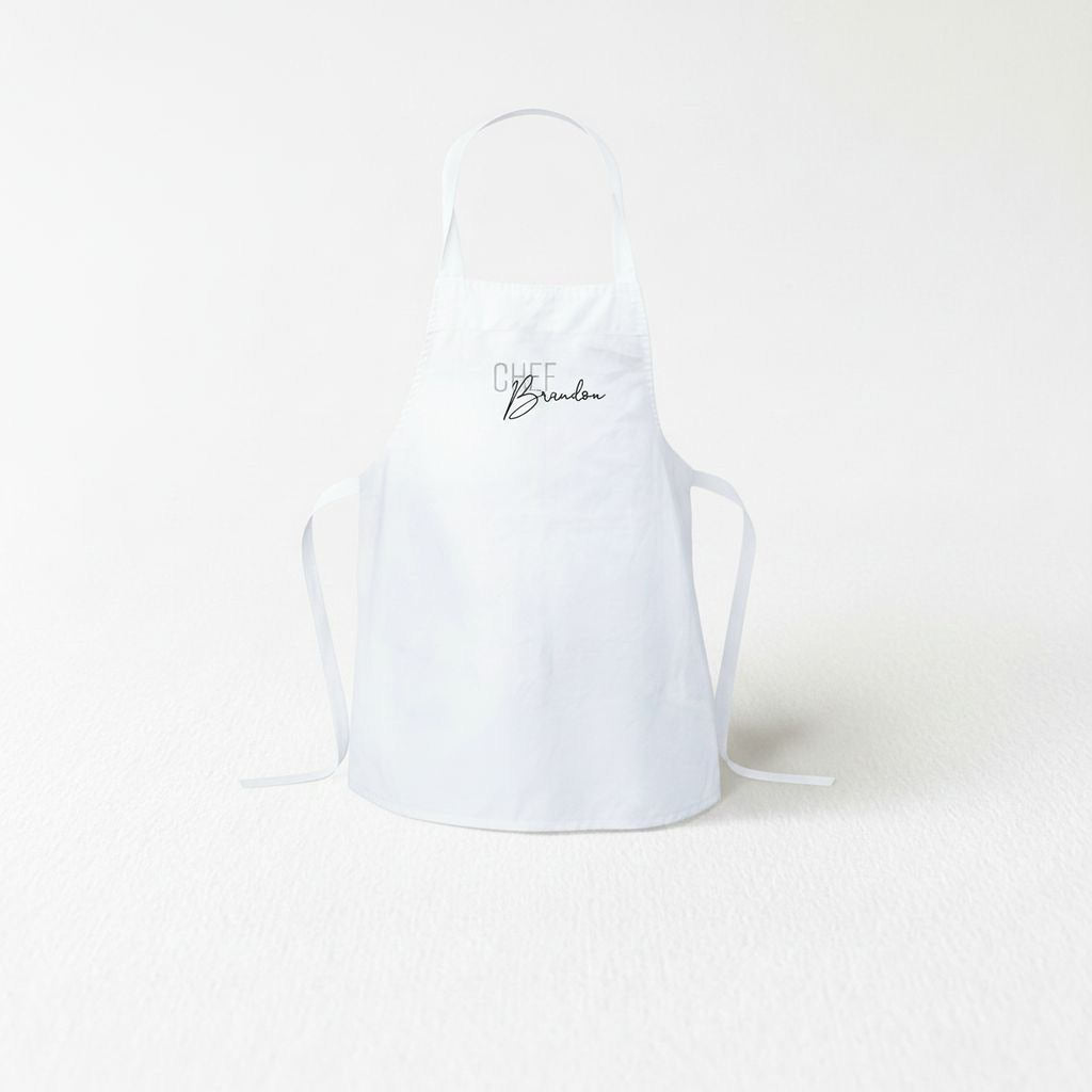 A white apron with the text "Chef Brandon" printed on it.