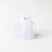A white apron with the text "Chef Brandon" printed on it.