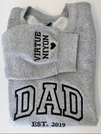 A grey sweatshirt with black text and graphics printed on it.