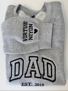 A grey sweatshirt with black text and graphics printed on it.