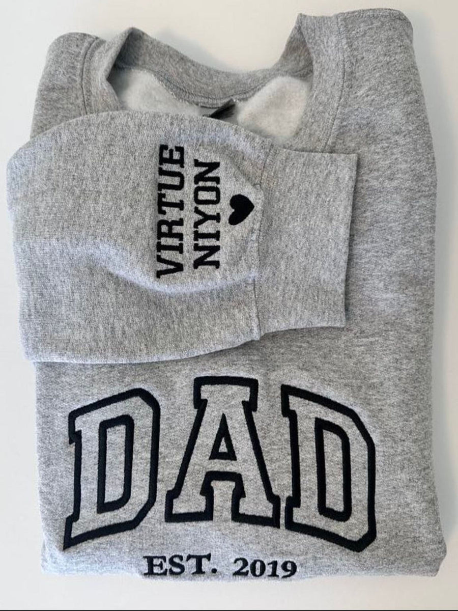 A grey sweatshirt with black text and graphics printed on it.