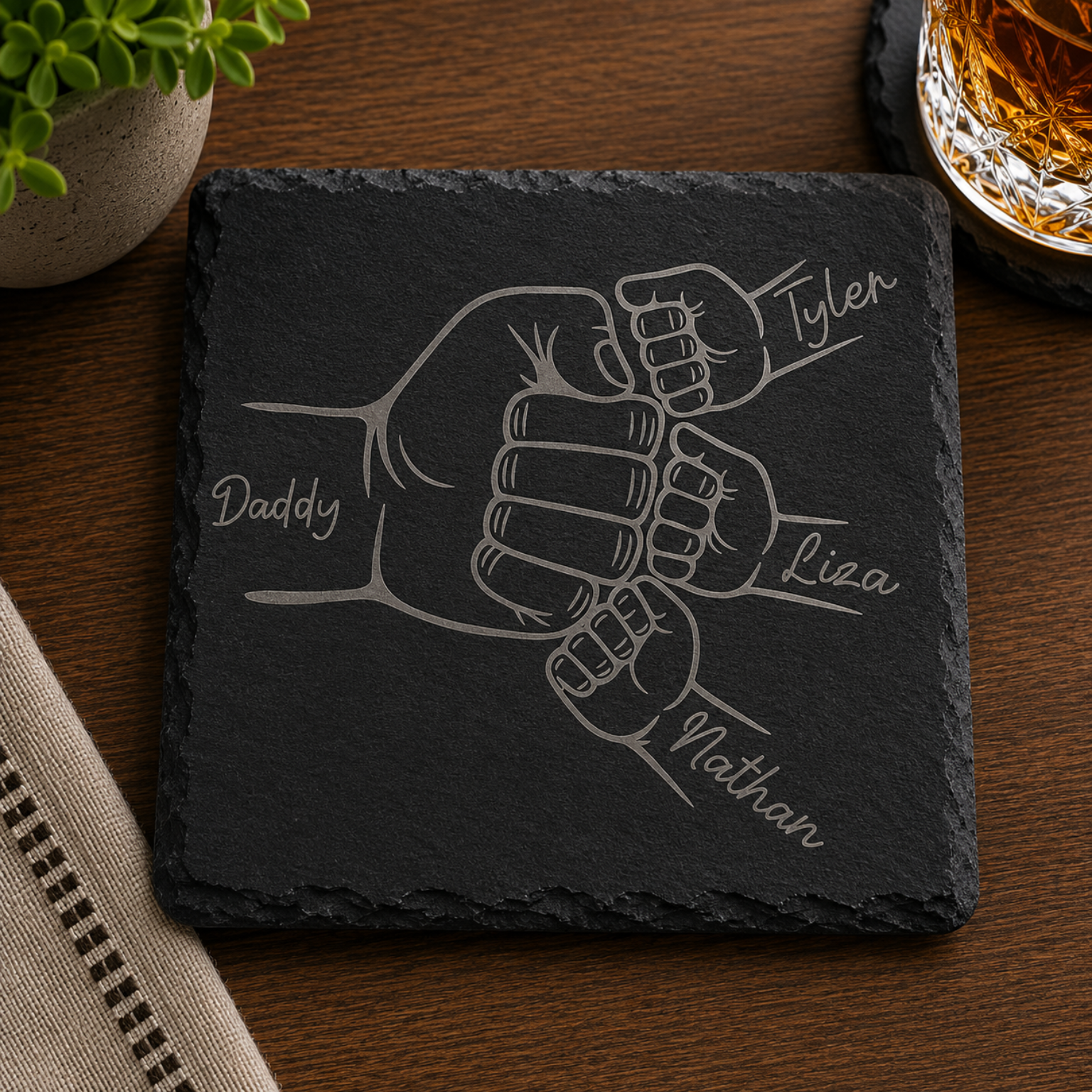 Personalized engraved black slate coaster featuring a fist bump design with Dad and children's names laser engraved on natural slate.