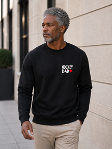Hockey Dad crewneck sweatshirt featuring a minimalist white Hockey Dad design with a red Canadian maple leaf, modeled outdoors.