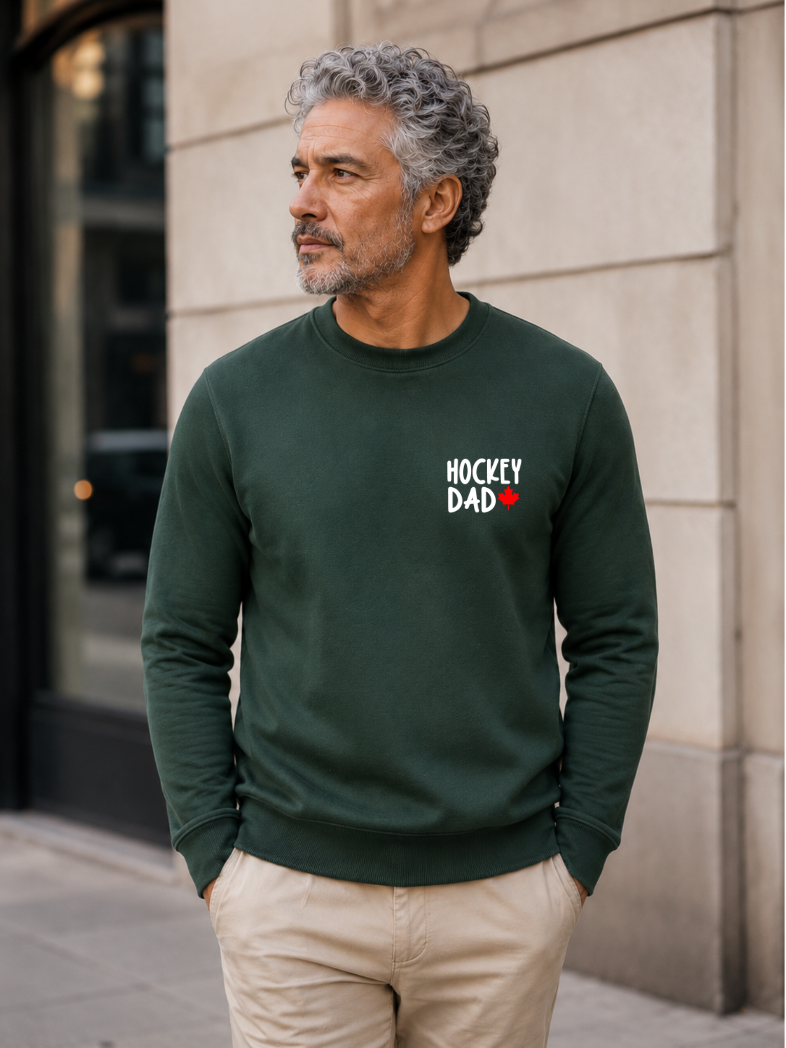 Hockey Dad crewneck sweatshirt featuring a minimalist white Hockey Dad design with a red Canadian maple leaf, modeled outdoors.