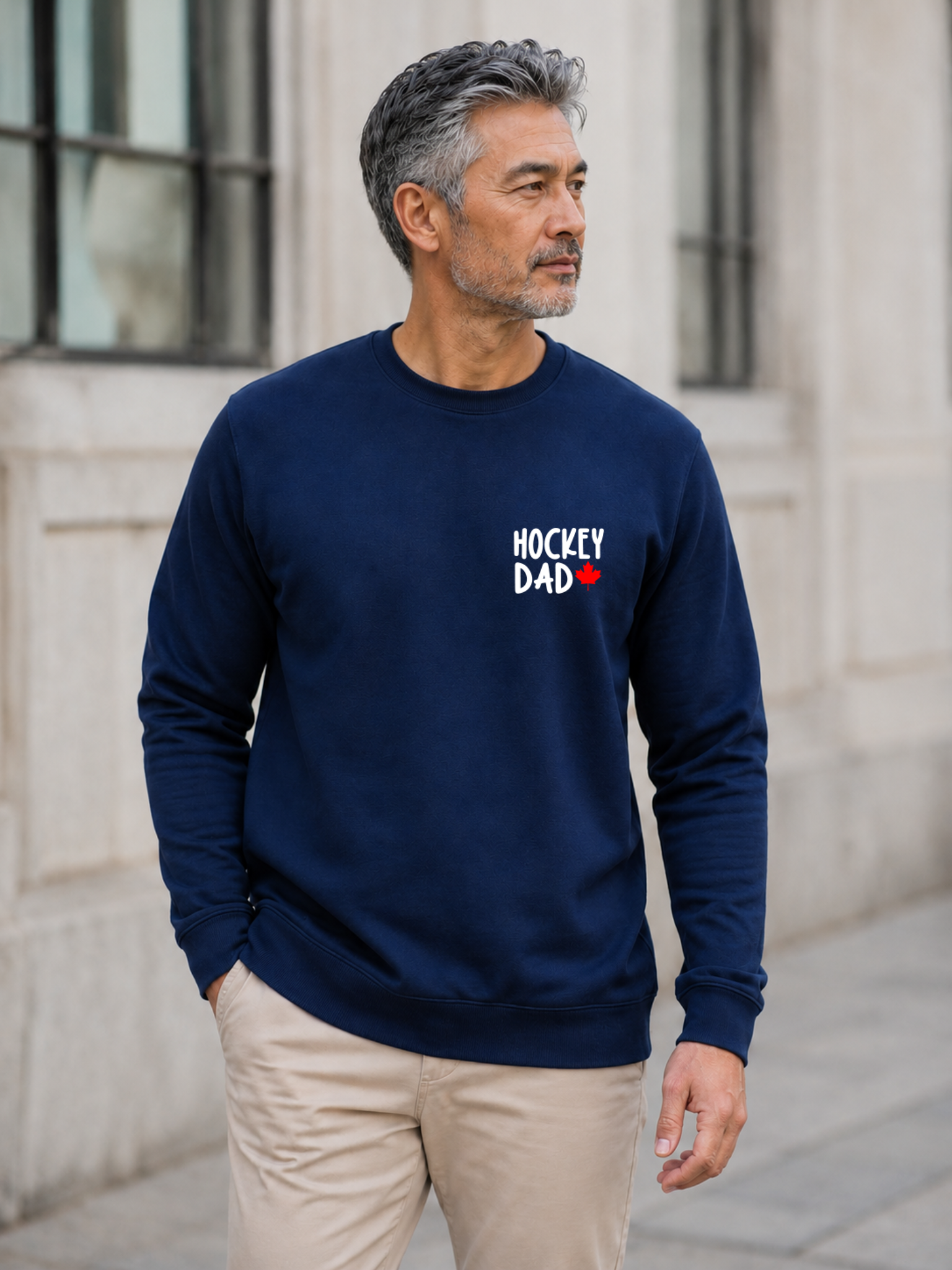 Hockey Dad crewneck sweatshirt featuring a minimalist white Hockey Dad design with a red Canadian maple leaf, modeled outdoors.