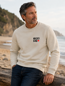 Hockey Dad crewneck sweatshirt featuring a minimalist white Hockey Dad design with a red Canadian maple leaf, modeled outdoors.