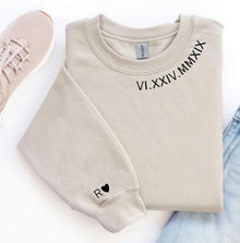 Beige sweatshirt with Roman numeral design and pink sneakers on a white background
