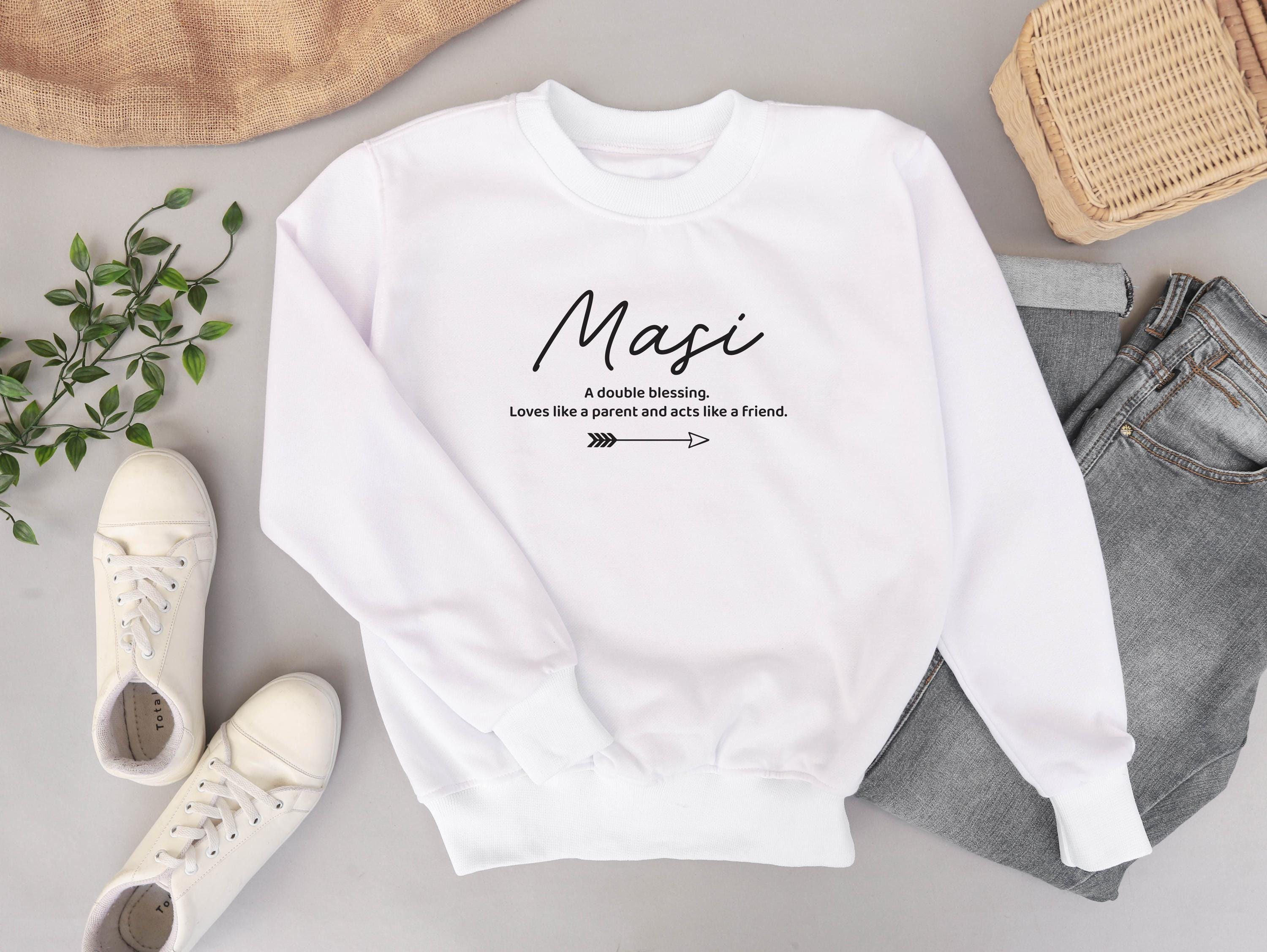 White sweatshirt with text on a gray surface with shoes and jeans