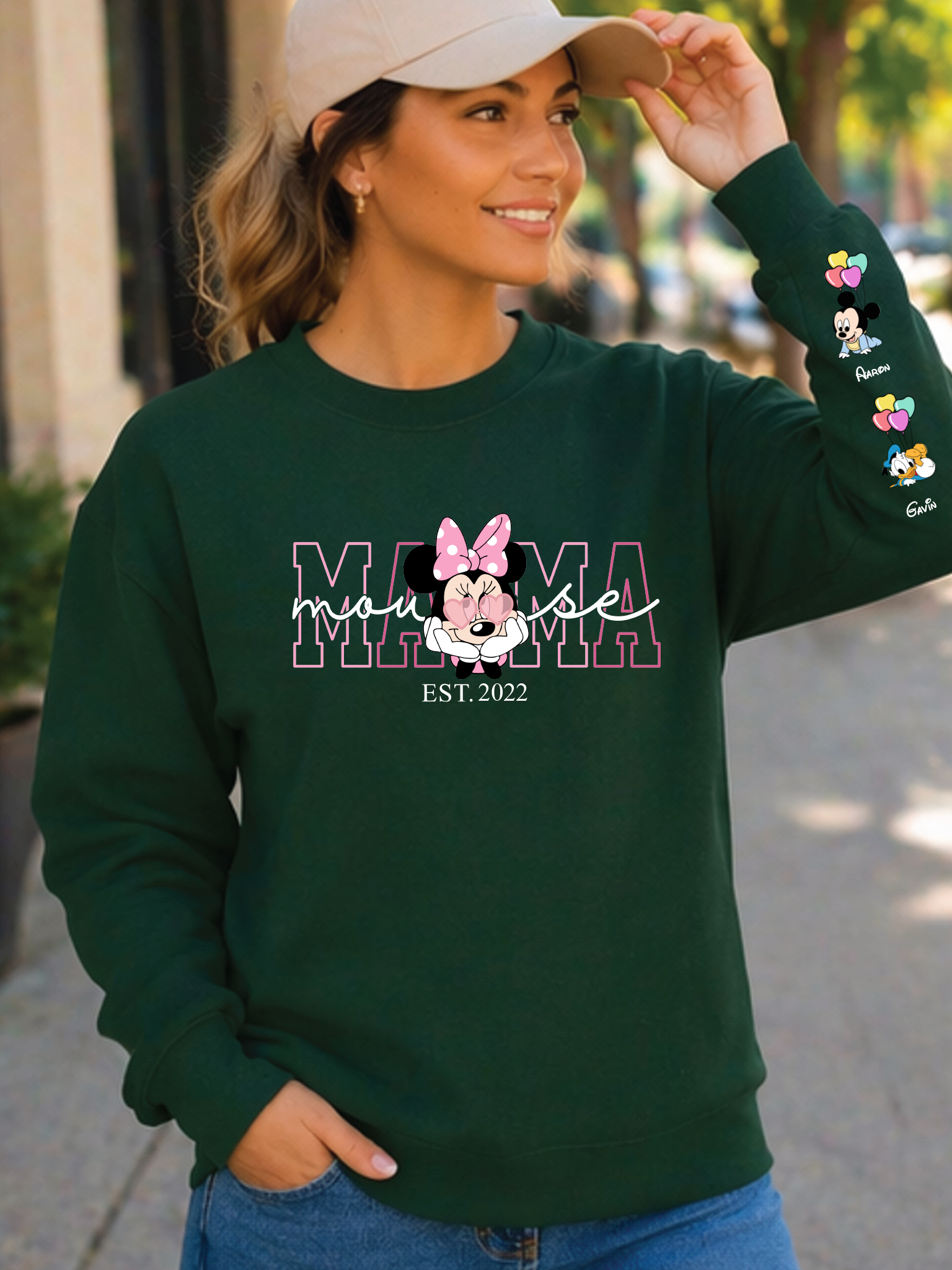 Woman wearing a green sweatshirt with 'Mama Mouse' design outdoors.