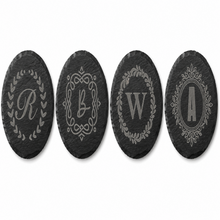Personalized round black slate coaster engraved with custom monogram initial, elegant decorative border design, custom wedding and housewarming gift.