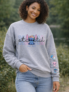 Person wearing a gray sweatshirt with 'Stitch' design, standing outdoors.