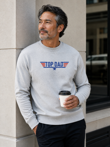 Top Dad sweatshirt featuring vintage distressed Father's Day graphic with patriotic stripes and star design worn by male model outdoors.